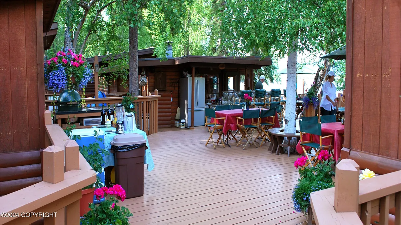 Deck arranged for entertaining with grill, tables, and seating