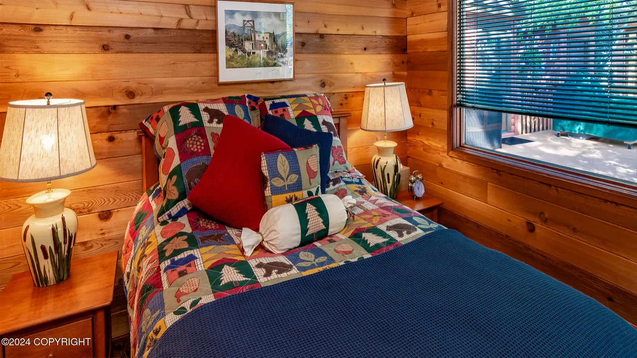 Guest cabin twin bedroom with quilt and twin lamps