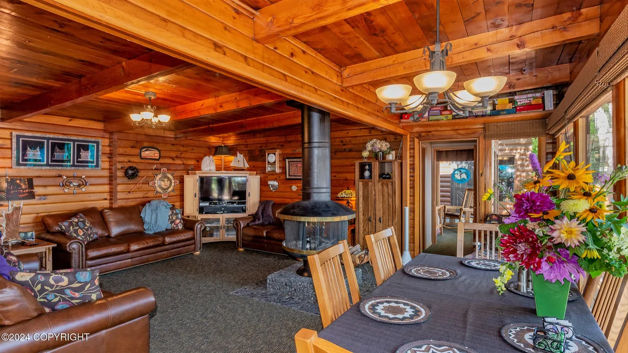Main cabin living and dining room around the central fireplace