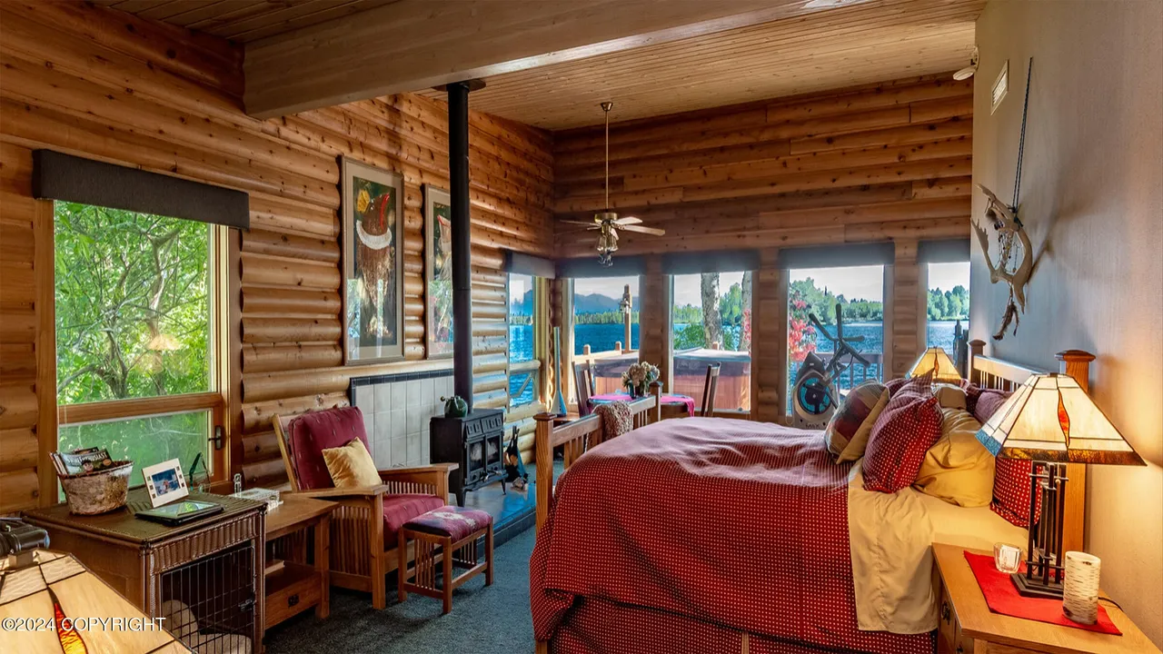 Primary bedroom with wall of windows facing Big Lake and the mountains
